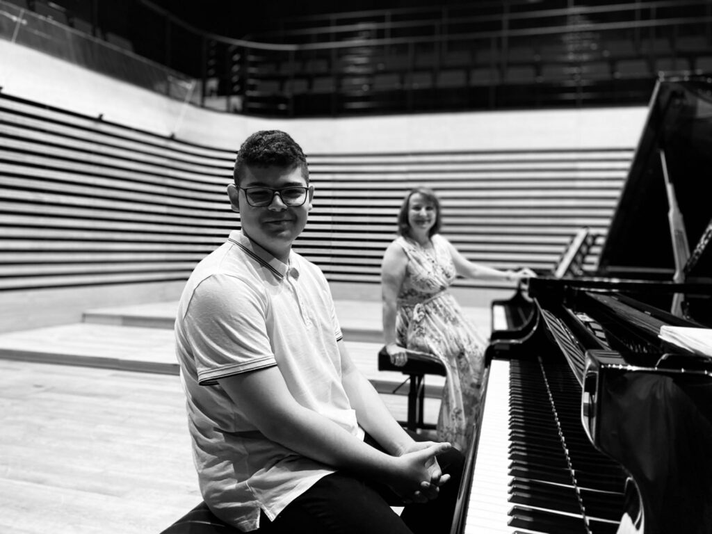 a man and woman sitting at piano