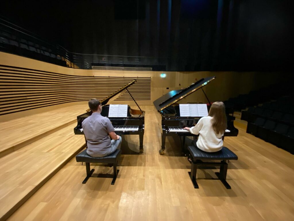 a man and woman playing piano