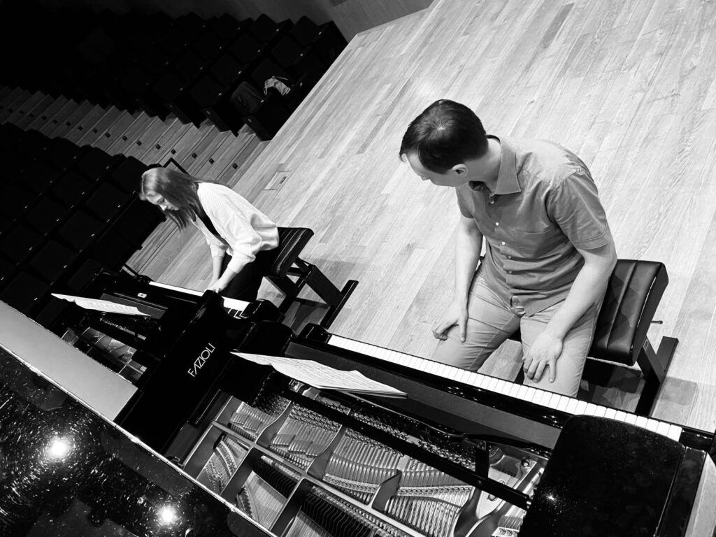 a man and woman sitting at a piano