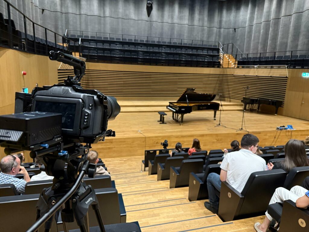 Piano na scenie w sali koncertowej.