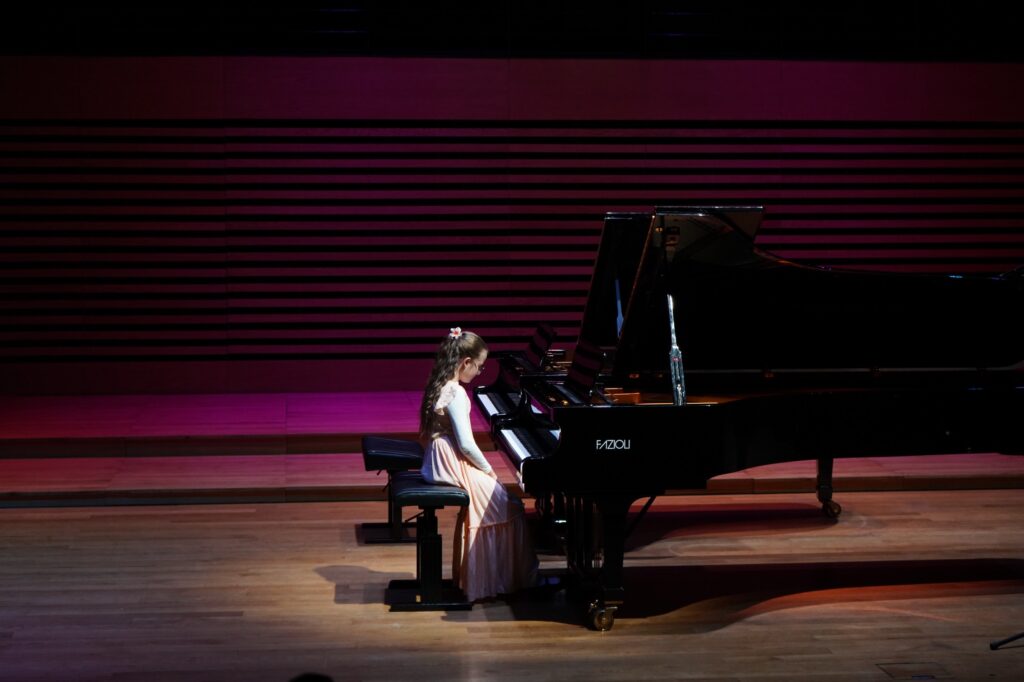 Dziewczynka gra na fortepianie.